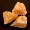 Oranje calciet ruw, gezuurd en met afmeting van circa 5 x 4 cm