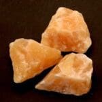 Oranje calciet ruw, gezuurd en met afmeting van circa 5 x 4 cm