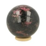 Fraaie donkere rhodoniet bol met diameter van 63mm op houten ring